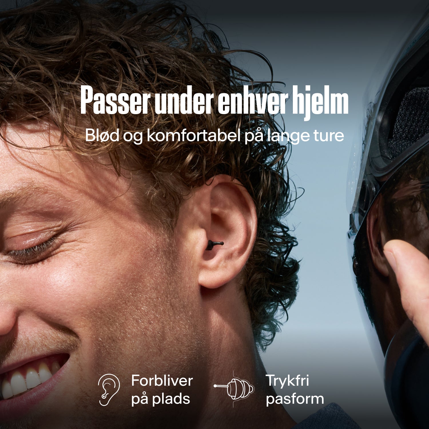 Mand med en Alpine MotoSafe Tour øreprop i øret ved siden af en hjelm, tekst "Passer under enhver hjelm – Blød og komfortabel på lange ture", "Forbliver på plads", "Trykfri pasform" 