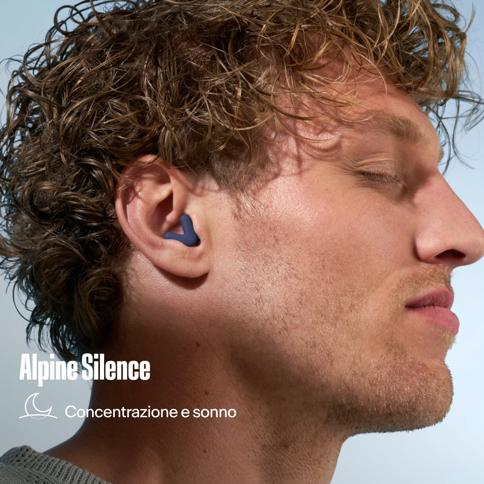 Tappo per le orecchie Alpine Silence indossato da un uomo con i capelli ricci, con la scritta &
