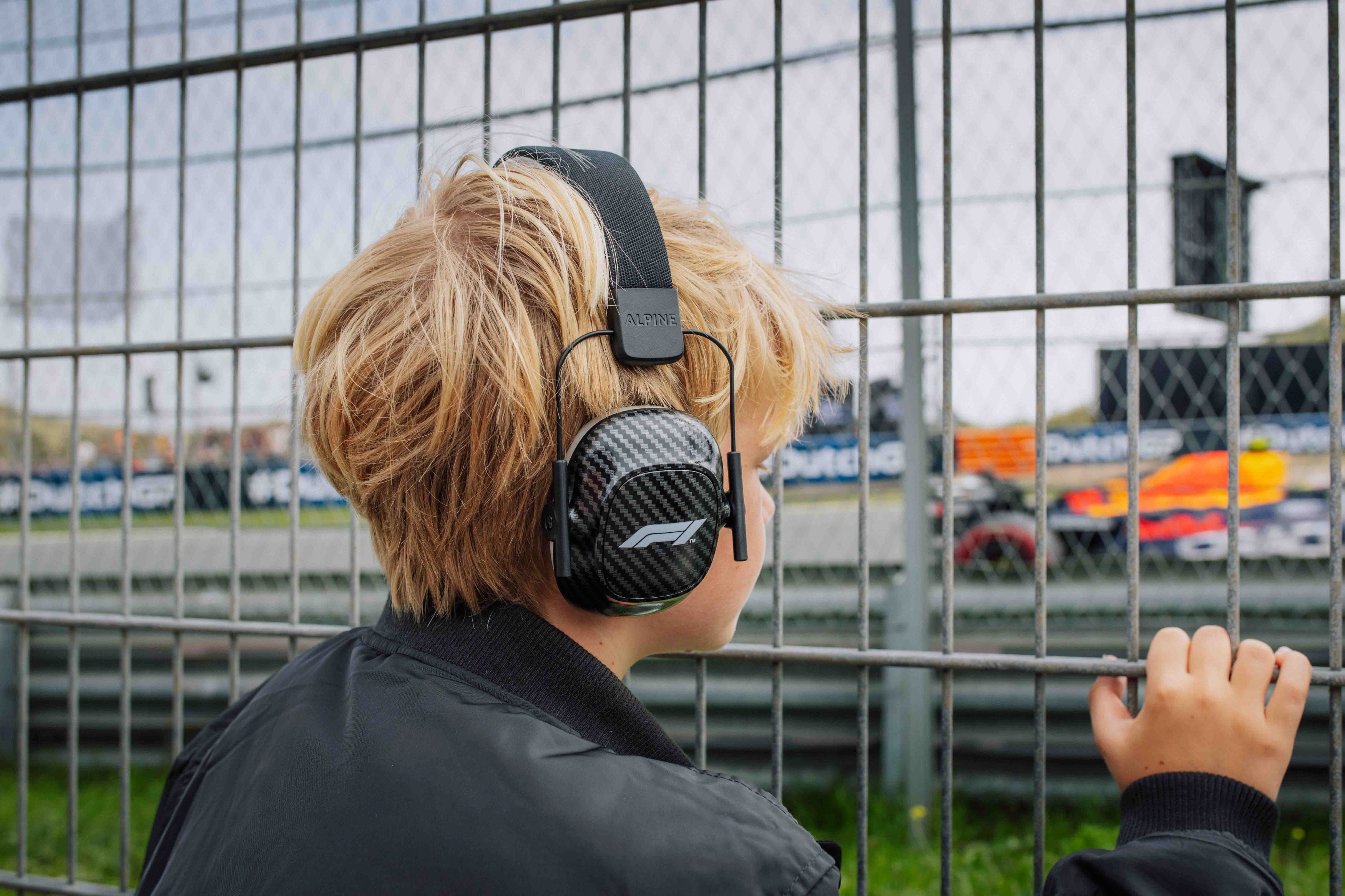 jongen aan de rand van een racebaan met Alpine Formula 1 Muffy