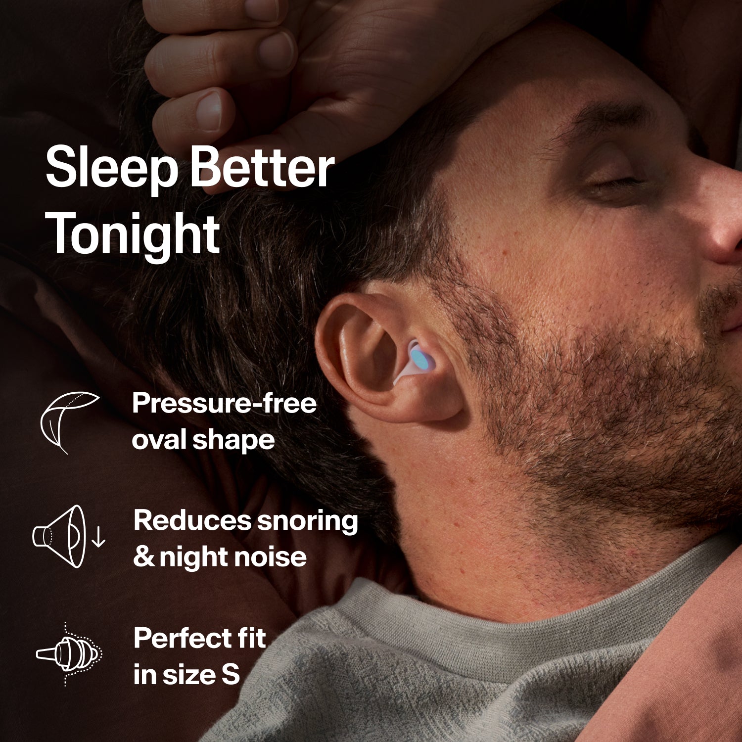 Man asleep on his side wearing an Alpine SleepDeep earplug, size S, to block snoring and night noise  