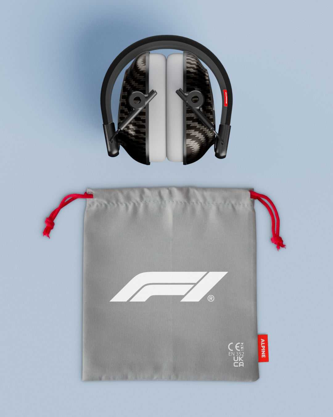 Folded Alpine Formula 1 Racing Muffy earmuffs above a grey drawstring pouch with red cords and F1 logo 
