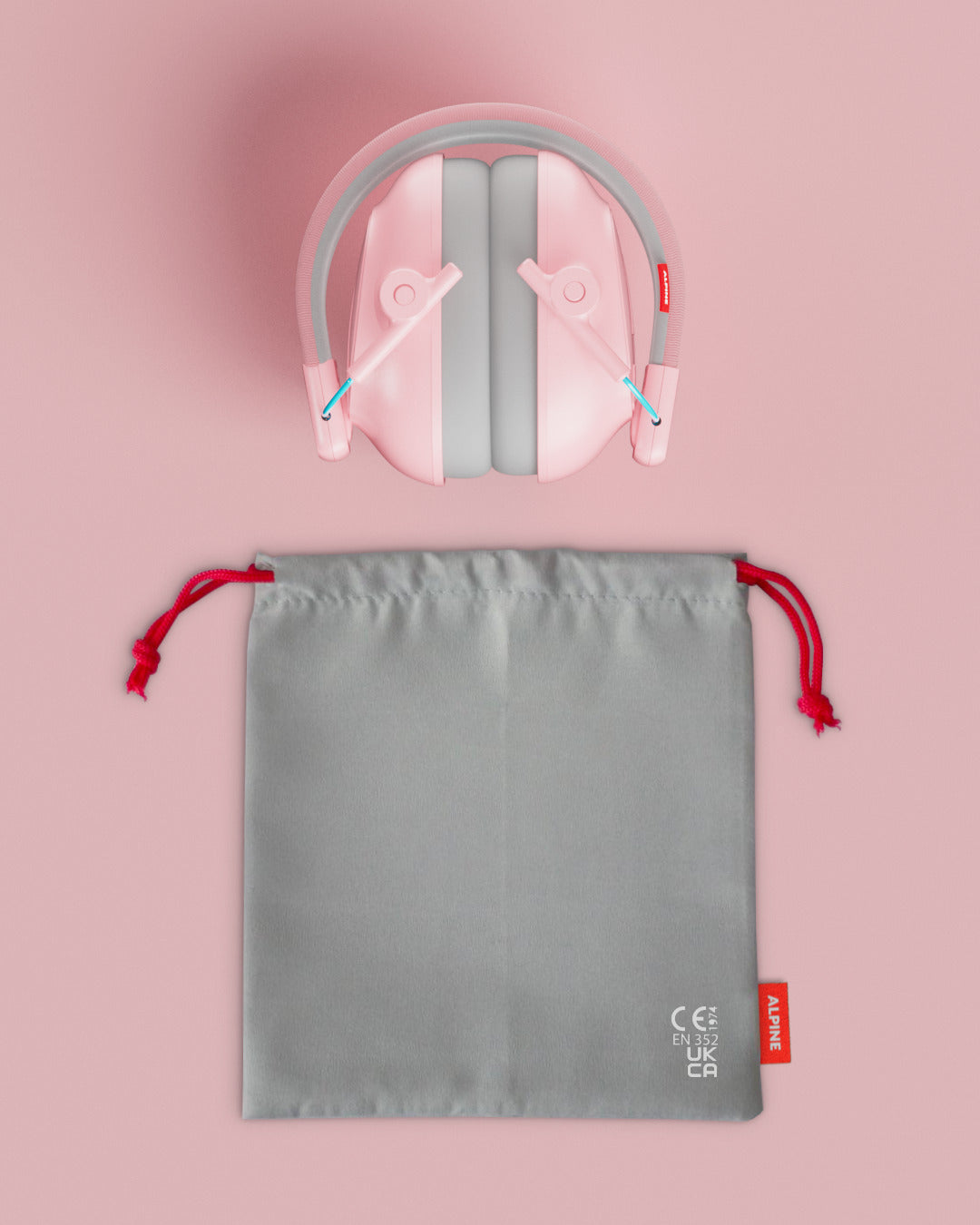 Alpine Muffy Baby ear defenders in pink, folded, with grey carrying pouch 